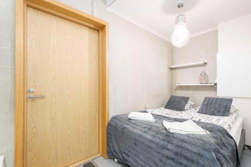 a bedroom with a bed and a wooden door at Apartments with free parking in Oulu