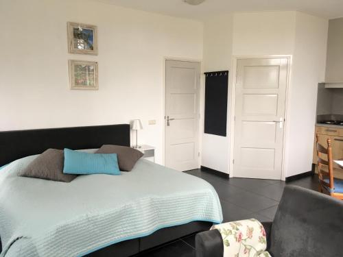a bedroom with a bed with blue pillows on it at De Borg Vakantie Appartementen in Winterswijk