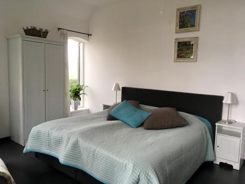 a bedroom with a bed with two pillows on it at De Borg Vakantie Appartementen in Winterswijk