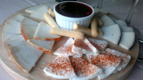 a plate of cheese and crackers and a cup of coffee at Hostal Restaurante Solaire in Castañar de Ibor