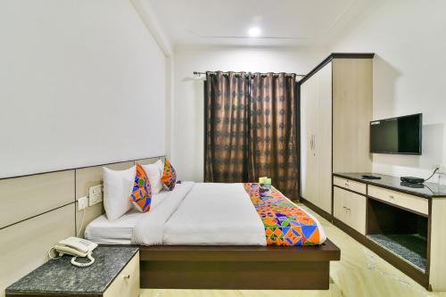 a hotel room with a bed and a desk at FabHotel Rallkmas Cyber City in Gurgaon