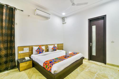 ein Schlafzimmer mit einem Bett in einem Zimmer mit einer Tür in der Unterkunft FabHotel Rallkmas Cyber City in Gurgaon