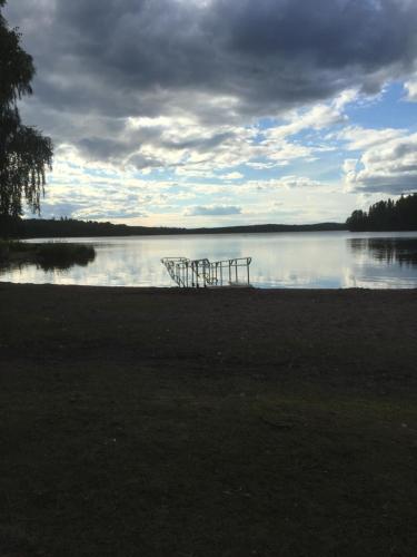 two chairs sitting on the shore of a lake at Odensvi Vandrarhem in Odensvi