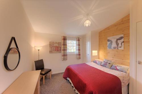 a bedroom with a bed and a desk and a mirror at Appin Holiday Homes -Caravans, Lodges, Shepherds Hut and Train Carriage stays in Appin