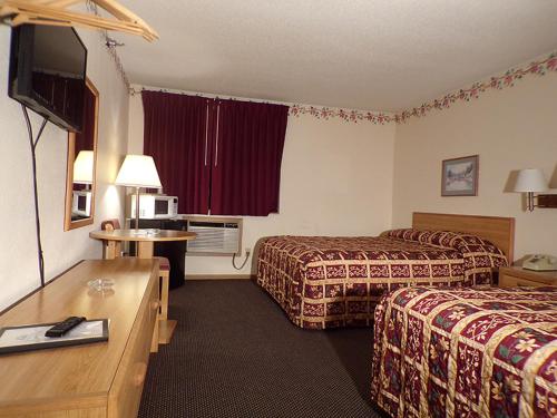 um quarto de hotel com duas camas e uma mesa em Morton Inn em Redwood Falls