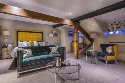 a living room with a green couch and a bed at The Castle Hotel, Conwy, North Wales - The Coaching Inn Group in Conwy
