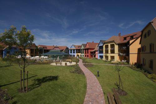 a park with houses and a brick walkway at Résidence Pierre & Vacances Le Clos d'Eguisheim in Eguisheim
