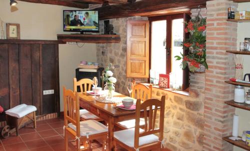 comedor con mesa de madera y sillas en Casa de Piedra, en Valderrueda