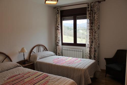 - une chambre avec 2 lits et une fenêtre dans l'établissement Apartamento Usarena en Ezcaray, à Zorraquín
