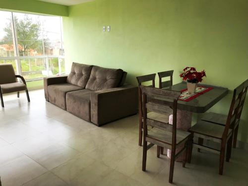a living room with a couch and a table at Residencial Veleiros Do Mar in Capão da Canoa