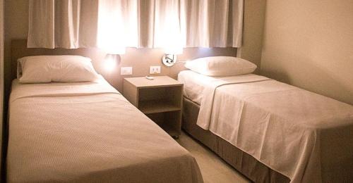 a hotel room with two beds and a window at Salinas Park Resort in Salinópolis