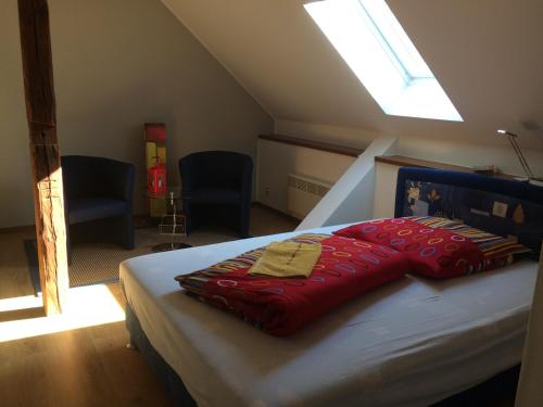 ein Schlafzimmer mit einem Bett mit einem roten Kissen darauf in der Unterkunft Pension Zum alten Gasthaus Hänsel in Krauschwitz