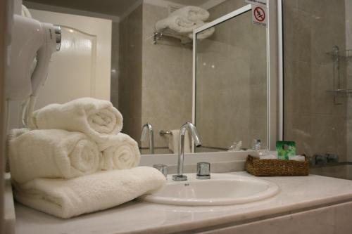 a bathroom with a sink and towels on a counter at El Aguila del Tuyu in San Clemente del Tuyú