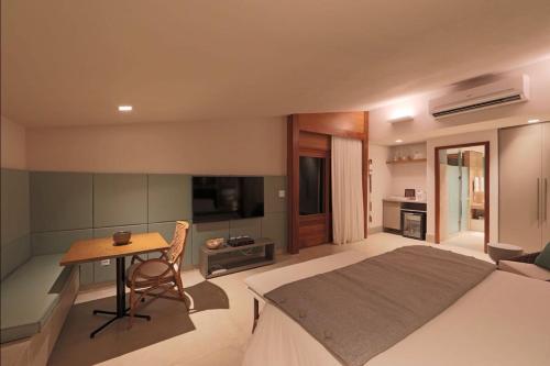a bedroom with a bed and a desk and a table at Pousada Zé Maria in Fernando de Noronha
