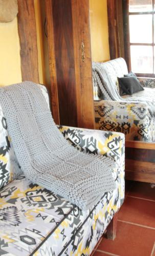a bedroom with a bed and a couch with a blanket at Casa de Piedra in Valderrueda