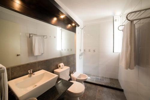 uma casa de banho branca com um lavatório e um WC em 27 Suites Hotel em Montevidéu