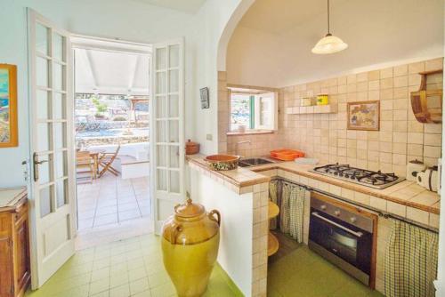 una cucina con lavandino e piano cottura forno superiore di Villa Scarnera by BarbarHouse a Corsano