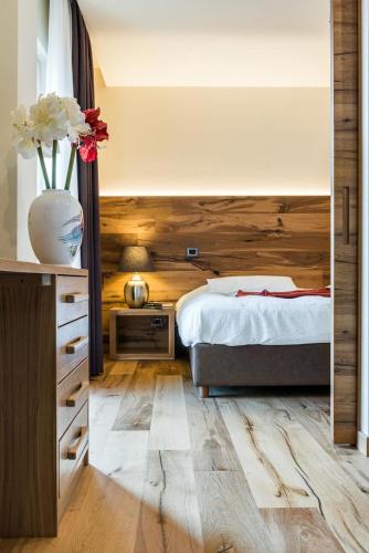a bedroom with a bed and a vase with flowers at Hotel Firenze in Fanano