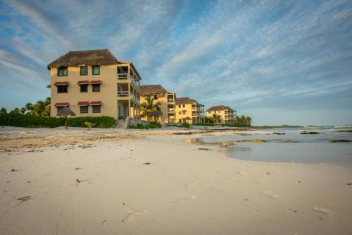 a building on a beach with the ocean at Caleta Tankah in Tulum