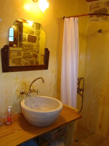 a bathroom with a bowl sink and a shower at Lithos Traditional Guest Houses in Xerokampos