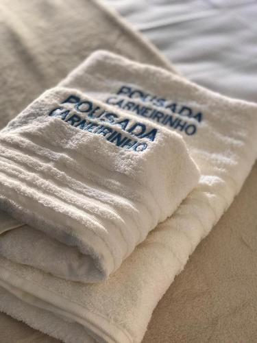 a pile of towels sitting on top of a bed at Pousada Carneirinho in Capitólio