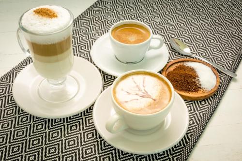 a table with two cups of coffee and two drinks at Caleta Tankah in Tulum