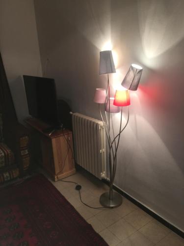 una camera con lampada, TV e parete di El Jenina Apartment a Alger
