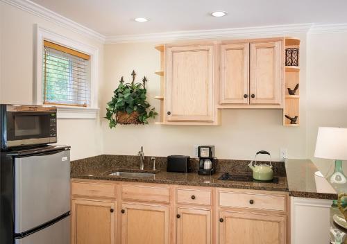 a kitchen with wooden cabinets and a stainless steel refrigerator at Anchorage by the Sea in Ogunquit