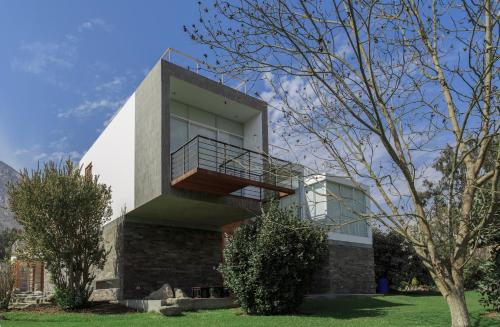 a house with a balcony on the side of it at Zen Home & Garden House in Cieneguilla