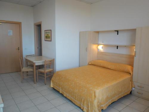 Un dormitorio con una cama y una mesa. en Polena Residence Hotel, en Marina di Montenero