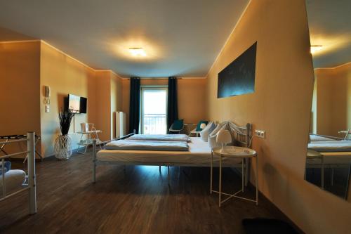 a room with two beds and a desk in it at Motel Füssen im Allgäu in Füssen