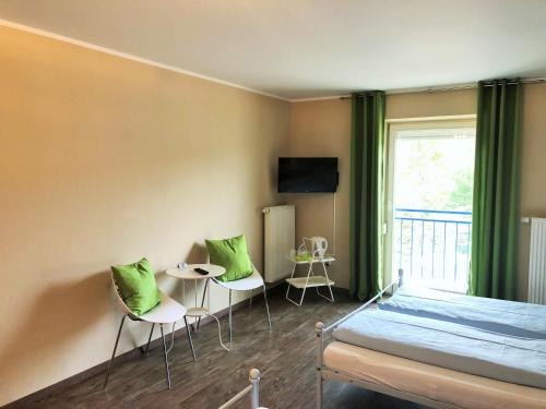a bedroom with a bed and two chairs and a table at Motel Füssen im Allgäu in Füssen