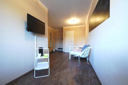 a living room with a table and a tv at Motel Füssen im Allgäu in Füssen
