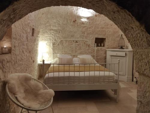 ein Schlafzimmer mit einem Bett in einer Steinmauer in der Unterkunft Trullo la perla di pietra in Alberobello