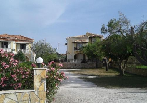a house with a gate and flowers in front of it at Vokamvilia Apartment & Studio Close to the sea in Plános