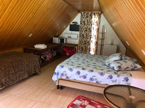 a bedroom with a bed and a table in a room at Chalés Abraço Serrano in Urubici