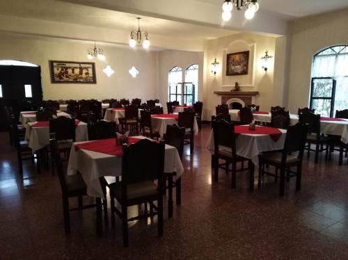 una sala da pranzo con tavoli, sedie e camino di La Chacra de Joel Hotel a Huehuetenango