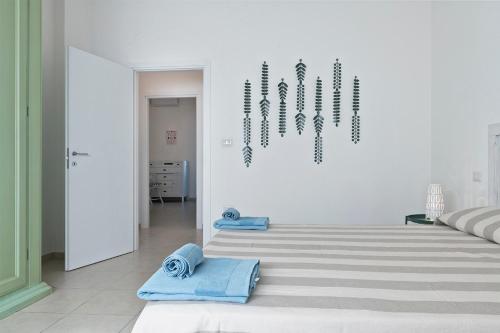 um quarto branco com duas toalhas azuis no chão em Casa Te Mare em Torre Suda