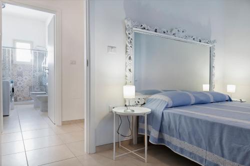 a bedroom with a blue bed with a large mirror at Casa Te Mare in Torre Suda