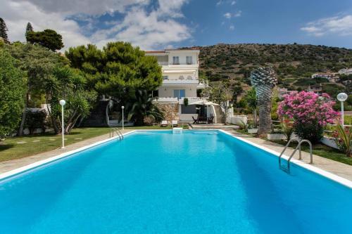 a swimming pool in front of a villa at Beautiful, Private Villa by the Sea in Aghia Marina