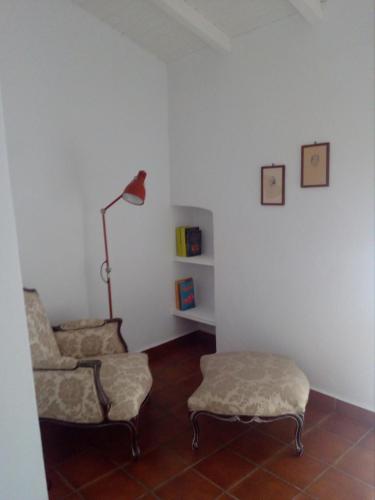 a living room with a chair and a lamp at Casas do Ardila in Santo Amador