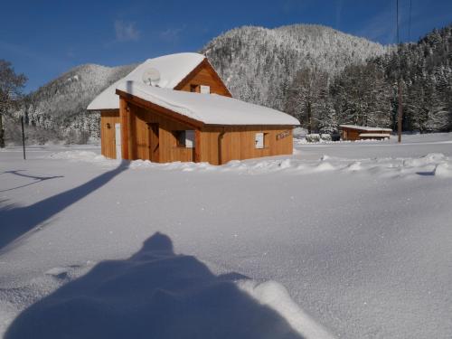 a wooden cabin with snow on the snow covered ground at Chalet pour amoureux de la nature avec vue sur le lac de Retournemer in Xonrupt-Longemer