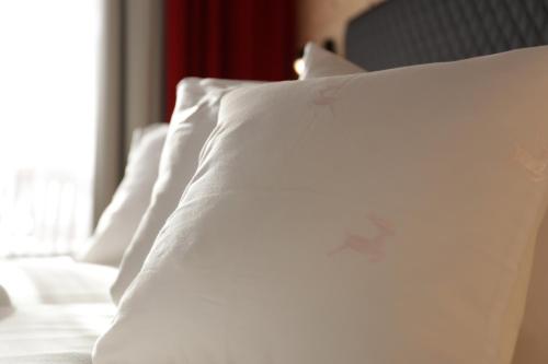 a close up of a white pillow on a bed at Boutique Hotel Längenfelder Hof in Grainau