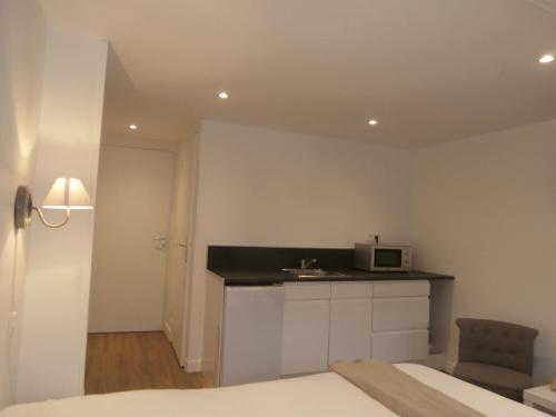 - une chambre avec un lit et un four micro-ondes sur un comptoir dans l'établissement au Claire de lune, à Dieppe