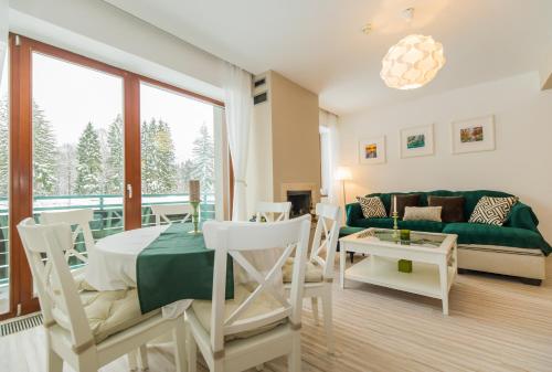 una sala de estar con un sofá y una mesa en Charming 2-Bedroom, Silver Mountain, A Building, en Poiana Brasov