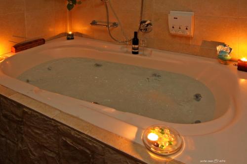 a bath tub with a candle and a bottle of champagne at Rosh Pinat Noy in Rosh Pinna