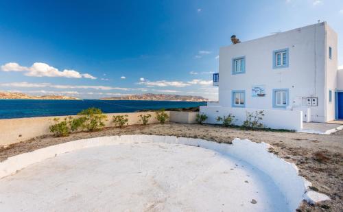 a white house with the ocean in the background at Polyegos View in Pollonia