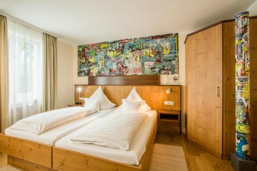 a bedroom with a large bed with white sheets at Hotel Brunner in Amberg