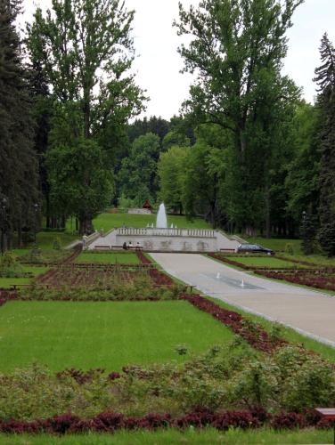 a park with a garden with a monument in the distance at Hotel Europa in Polanica-Zdrój