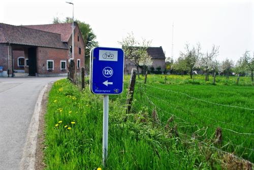 a blue sign on the side of a road at De Notelaar in Kortessem